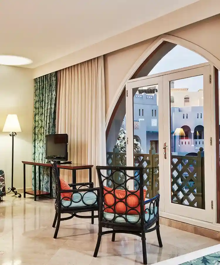 A room at Fanadir el Gouna with open curtain, overlooking a scenic view.