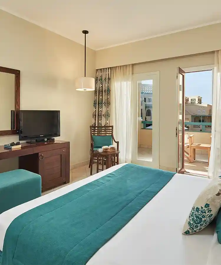 Hotel room featuring a king-sized bed and open curtains, inviting natural light into the serene space.