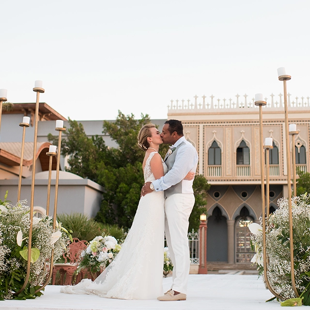 A bride and groom sharing a romantic kiss at La Maison Bleue el Gouna, capturing a moment of love and celebration.