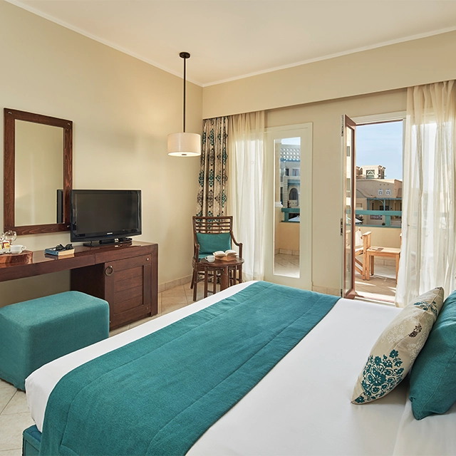 Hotel room featuring a king-sized bed and open curtains, inviting natural light into the serene space.