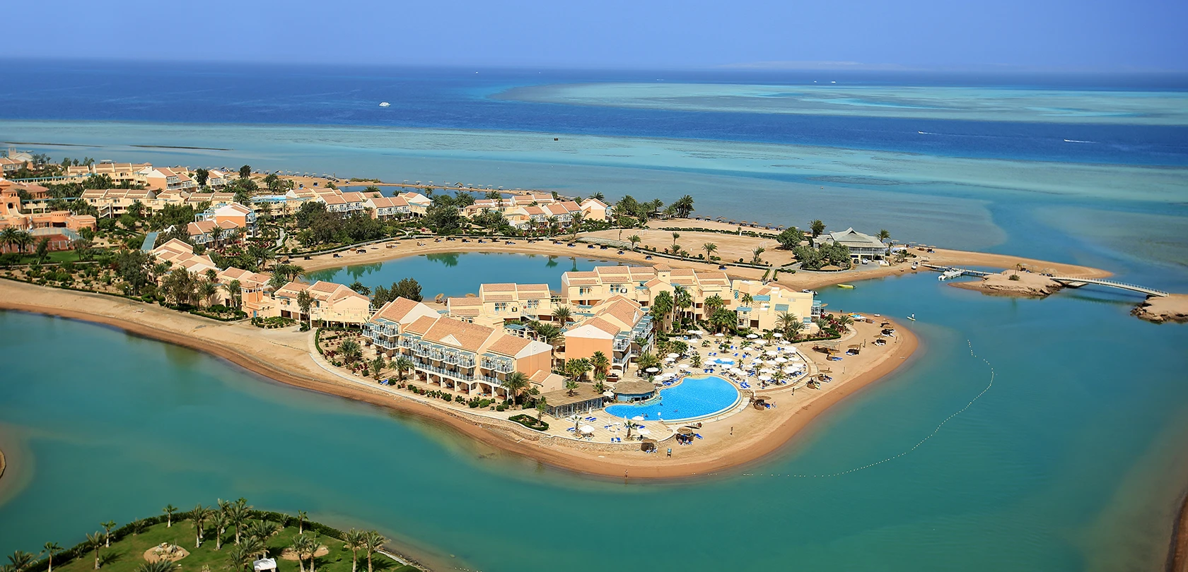 Aerial view of Mövenpick Hotel El Gouna showcasing its pools, a lagoon, and the adjacent Red Sea coastline.