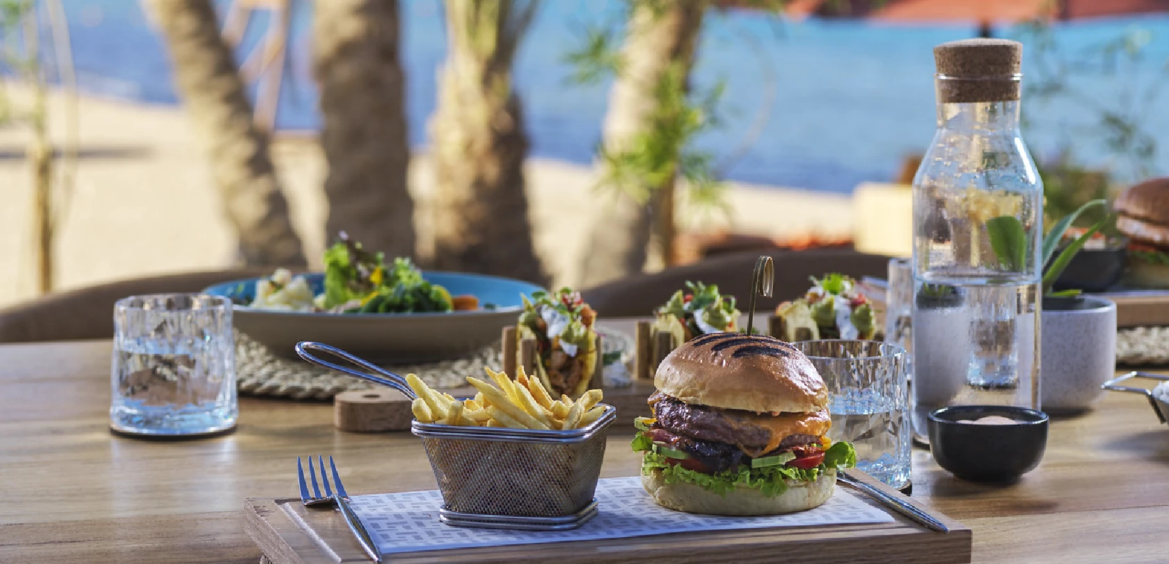 Dining experience at Chedi featuring a gourmet burger with French fries on a stylishly set table.