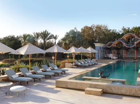 The pool area at La Maison Bleue el Gouna, featuring umbrellas and comfortable lounges for guests to relax and enjoy.