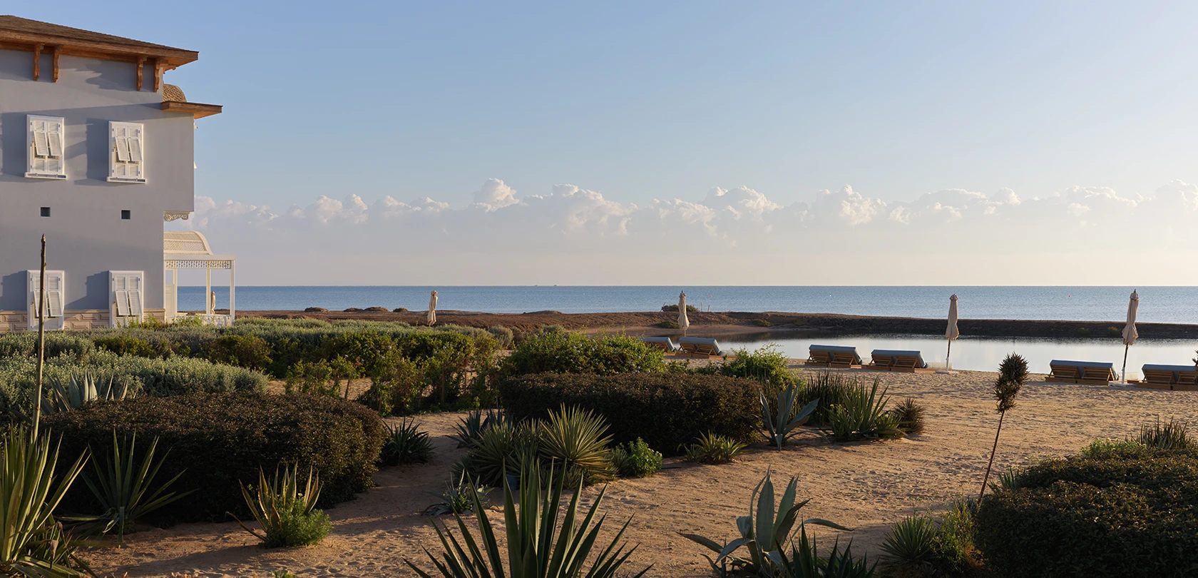 Lagoon-side view at La Maison Bleue El Gouna, featuring serene waters and lush surroundings.