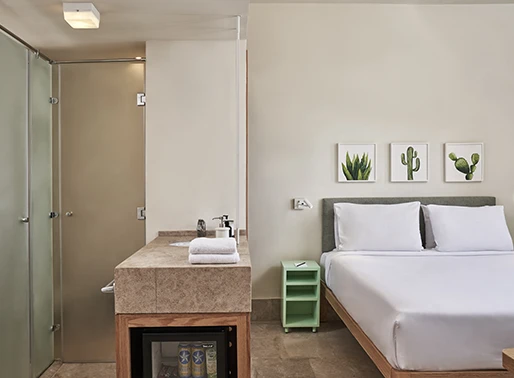 Junior suite at El Gouna, Red Sea, Egypt, featuring a well-appointed room with a minibar. The suite includes a comfortable bed with stylish linens, a cozy seating area, and a modern decor. The minibar is stocked with a selection of beverages and snacks, enhancing the convenience and comfort of the stay. The overall design of the suite blends luxury and functionality, offering a relaxing and enjoyable retreat for guests.